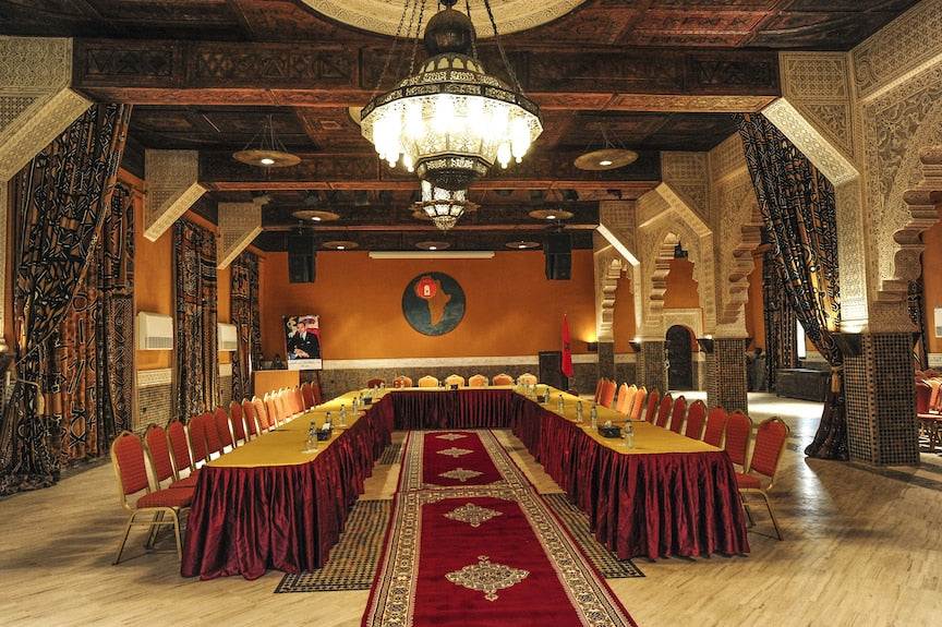 Kasbah Hotel Xaluca dining or conference room with red and gold chairs, patterned curtains, Moroccan decor and chandeliers