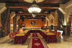 Kasbah Hotel Xaluca dining or conference room with red and gold chairs, patterned curtains, Moroccan decor and chandeliers