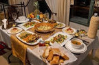 Kasbah Le Touareg traditional Moroccan dining table set with assorted dishes, bread, and decorative tablecloth in warm tones