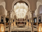 La Mamounia Marrakech elegant lobby with grand crystal chandeliers, marble floors, arched columns, and ambient lighting