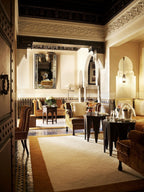Elegant Moroccan interior of La Mamounia Marrakech with carved arches, traditional lighting, plush seating, and warm tones