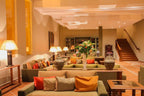 Le Berbere Palace Ouarzazate hotel lobby with green sofas, colorful throw pillows, warm lighting, and decorative flower arrangements