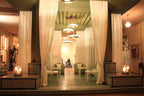 Le Berbere Palace Ouarzazate hotel lounge with olive green tiled floors, cream sheer curtains, and cozy seating area