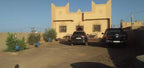 Maison Riad Tamarighte traditional beige Moroccan riad with ornate facade and multiple parked cars in front courtyard