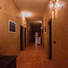 Maison Riad Tamarighte interior hallway with warm earth-toned walls, traditional lighting fixtures, and framed artwork