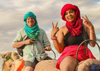 Marrakech Agafay Desert camel ride with two people in colourful red and teal traditional scarves