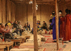 Marrakech Agafay Desert dinner show with seated guests and performers in colorful traditional Moroccan robes