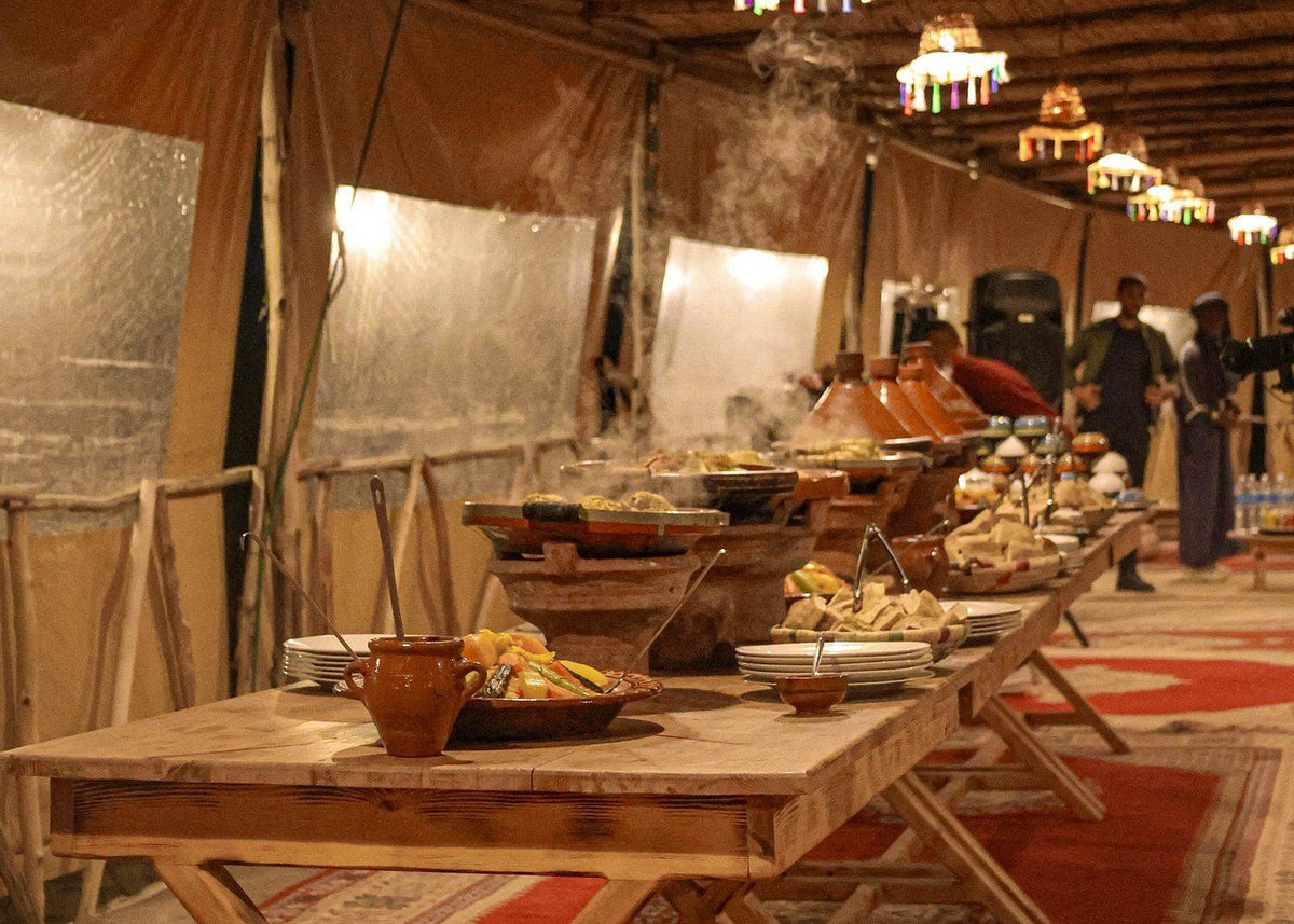 Marrakech Agafay Desert buffet dinner with Moroccan tagines, ceramic dishes, and traditional tent decor