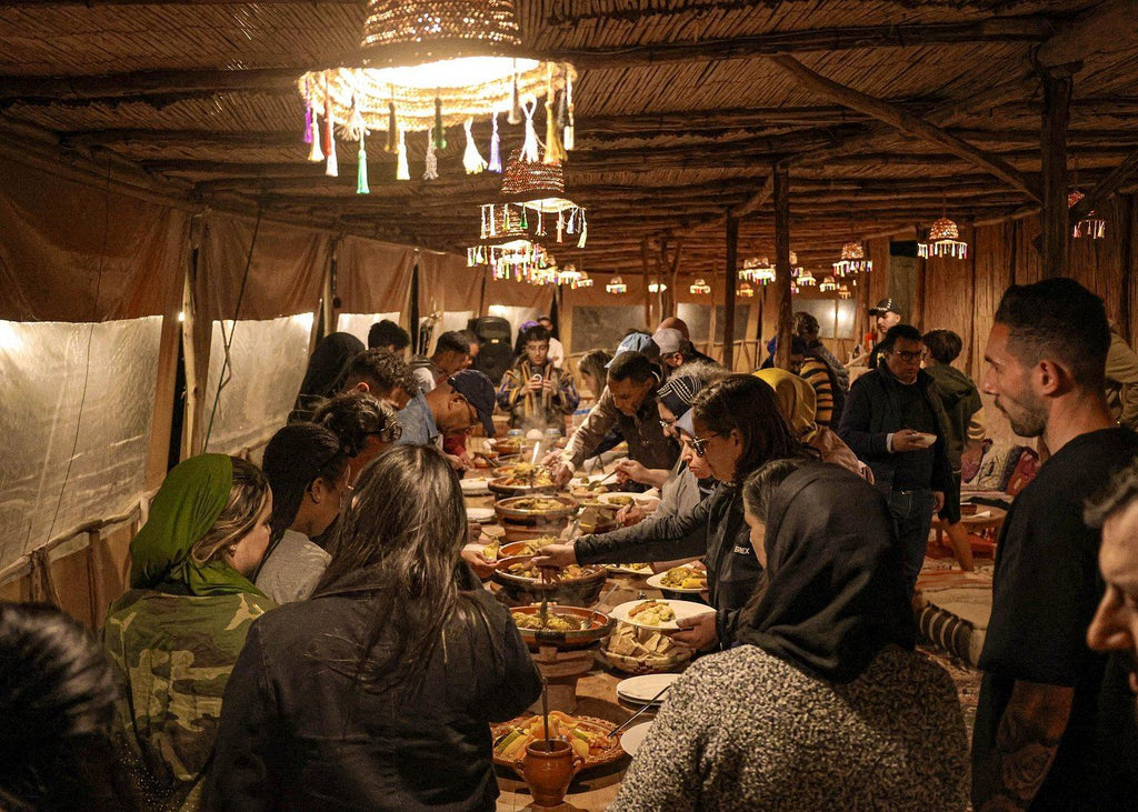 Marrakech Agafay Desert traditional Moroccan dinner served to diners inside a rustic Berber-style tent