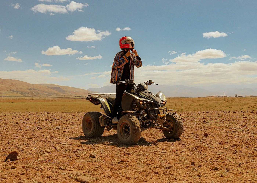Marrakech Agafay Desert quad bike with helmeted rider on rocky ochre terrain