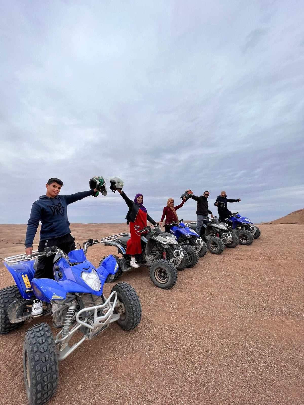 Marrakech Agafay Desert quad biking tour with riders posing beside blue and black all-terrain quad bikes