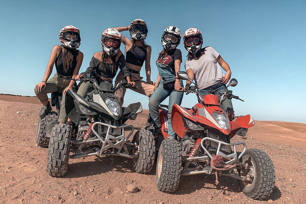 Marrakech Agafay Desert quad biking tour with five helmeted riders on black and red all-terrain quad bikes