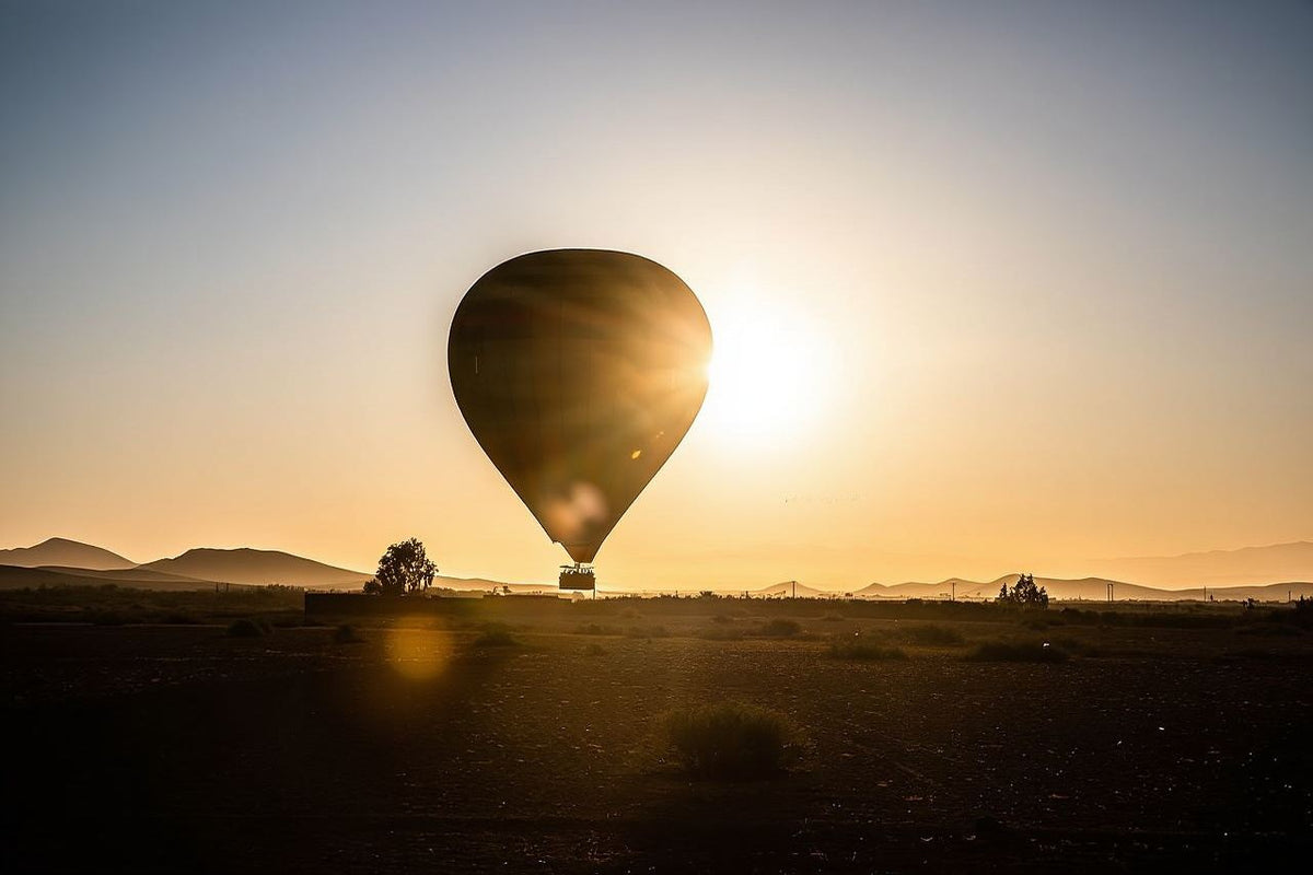 Marrakech by air hot air balloon with brown envelope and passenger basket floating over a desert landscape