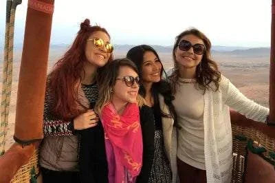 Marrakech by air hot air balloon basket with four smiling women wearing casual patterned clothing