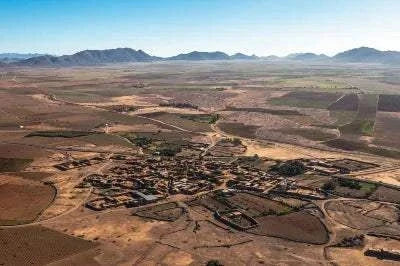 Marrakech by air hot air balloon view of Morocco's arid landscape, villages, fields and distant mountains