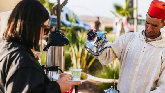 Marrakech by air Moroccan tea service with a silver teapot, white robe, and red fez