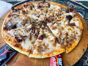 Thin-crust pizza with melted cheese, ground meat, and herbs on a wooden board, showcasing a Merzouga Cooking Class dish.