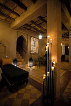 merzouga hotel kanz erremal cozy rustic interior with warm earthen tones, tiled floor, decorative lanterns, and ambient candle lighting