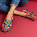 Moroccan Berber leather moccasins with colorful embroidered geometric patterns and black soles, perfect for Merzouga Shopping.