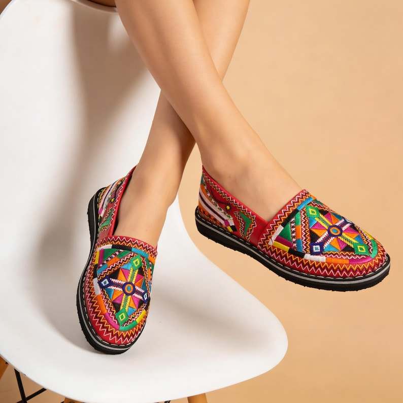 Moroccan leather moccasins for women in red with colorful embroidered geometric patterns and black soles, Merzouga Shopping style.