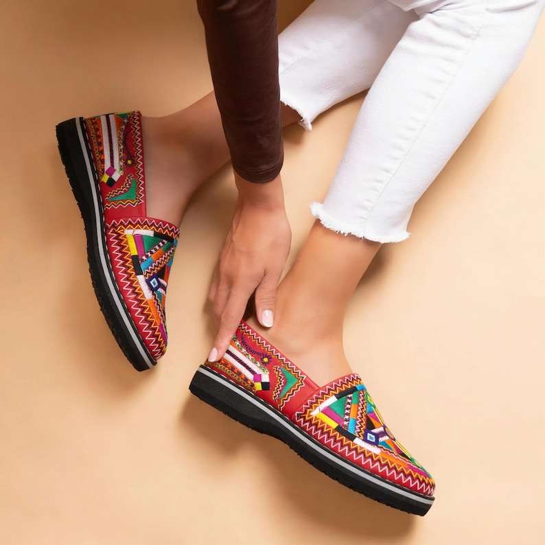 Moroccan leather moccasins with vibrant multicolor embroidered patterns and black soles, perfect for Merzouga Shopping style.