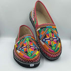 Moroccan leather moccasins in red with colorful intricate embroidered geometric patterns, black sole, Merzouga Shopping style.