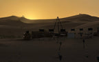 Moonlight luxury Desert Camp setting with silhouetted chairs arranged in a desert at sunset with sand dunes in the background