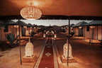 Moonlight luxury Desert Camp with illuminated ornate lanterns, traditional carpets, and luxury tents at dusk in desert