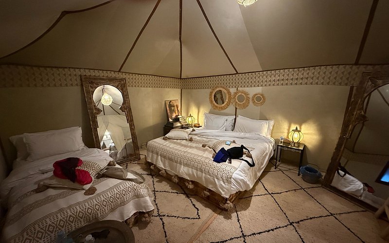 Moonlight luxury Desert Camp interior with two beds, warm beige fabric walls, patterned bedspreads, and decorative mirrors