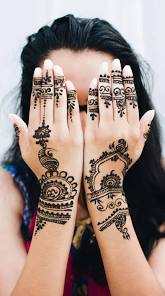 Moroccan Henna Tattoo featuring intricate black geometric and floral patterns on both hands and wrists of a person.