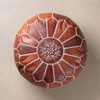 Moroccan pouf in brown leather with hand-stitched white embroidery and geometric petal pattern on top, round shape