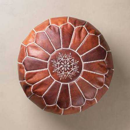 Moroccan pouf in brown leather with hand-stitched white embroidery and geometric petal pattern on top, round shape