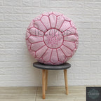 Moroccan pouf in soft pink leather with intricate stitched pattern and star detail, round handmade ottoman
