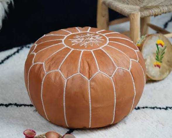 Round tan leather Moroccan pouf with white stitched geometric pattern and star design on top, handmade ottoman