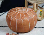 Round tan leather Moroccan pouf with white stitched geometric pattern and star design on top, handmade ottoman