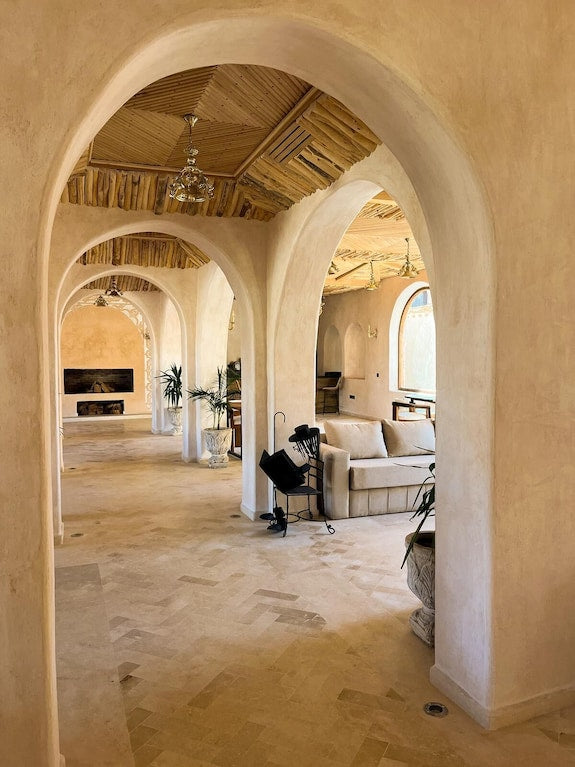 Interior of Nasser Palace Suites & Spa featuring beige arches, natural wood ceiling, and comfortable seating areas