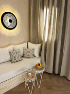 Nasser Palace Suites & Spa cozy seating area with beige curtains, white cushions, patterned pillows, and wooden side tables