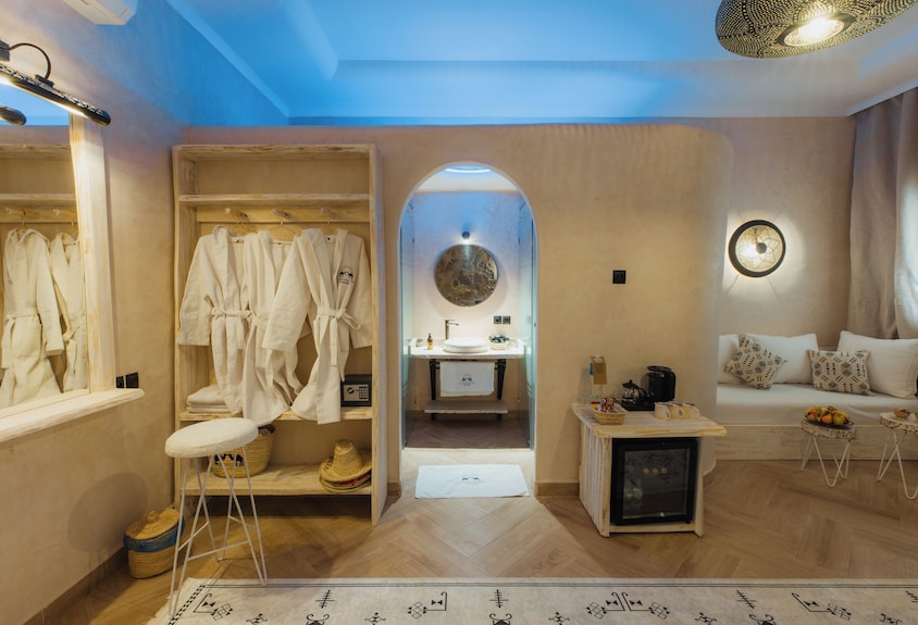 Nasser Palace Suites & Spa cozy room with beige walls, wooden flooring, white bathrobes, and modern Moroccan decor