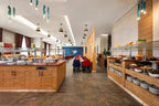 Novotel Makkah Thakher City restaurant with modern wood buffet counters, glass food displays, and colourful dining chairs