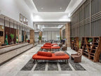Novotel Makkah Thakher City hotel lobby with modern marble interior, red sofas, wood shelving, and Saudi flags