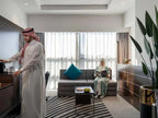 Novotel Makkah Thakher City hotel suite with modern furnishings, grey sofa, teal cushion, and guests