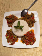 Berber pizza plate with red pepper, olives, and herbs surrounding a circular rice mound garnished with mint, perfect to Order Pizza.