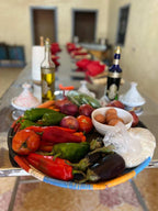 Basket of fresh vegetables including red and green peppers, onions, eggplants, eggs, and rice, inviting you to Order Pizza.