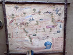Hand-painted rustic map on parchment paper framed with wooden branches featuring locations and landmarks in Morocco’s Sahara region.