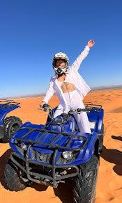 blue quad bike with black accents on orange sand dunes under clear blue sky during a quad bike ride