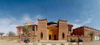 Residence Touristique Merzouga building with traditional Moroccan desert architecture in earthy tones and palm trees