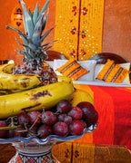 Riad Chay Boutique fruit bowl with bananas, pineapple, and grapes in bright Moroccan-style room with orange and yellow decor