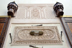Intricate Moroccan architectural wall carvings in soft beige plaster with engraved floral and geometric patterns at Riad Dar Tahri SPA