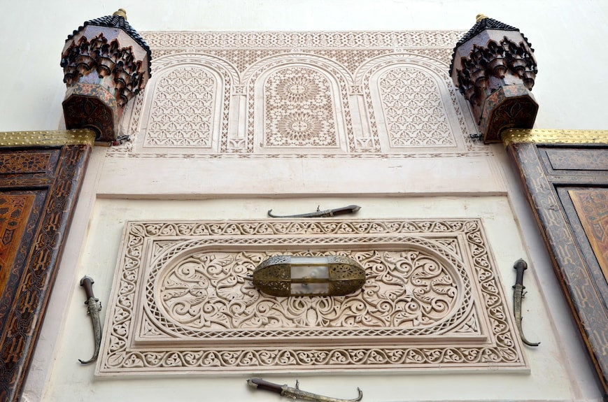 Intricate Moroccan architectural wall carvings in soft beige plaster with engraved floral and geometric patterns at Riad Dar Tahri SPA