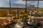 Riad Dar Tahri SPA rooftop breakfast table with orange juice, fresh bread, eggs, silver teapot, and outdoor seating with city view